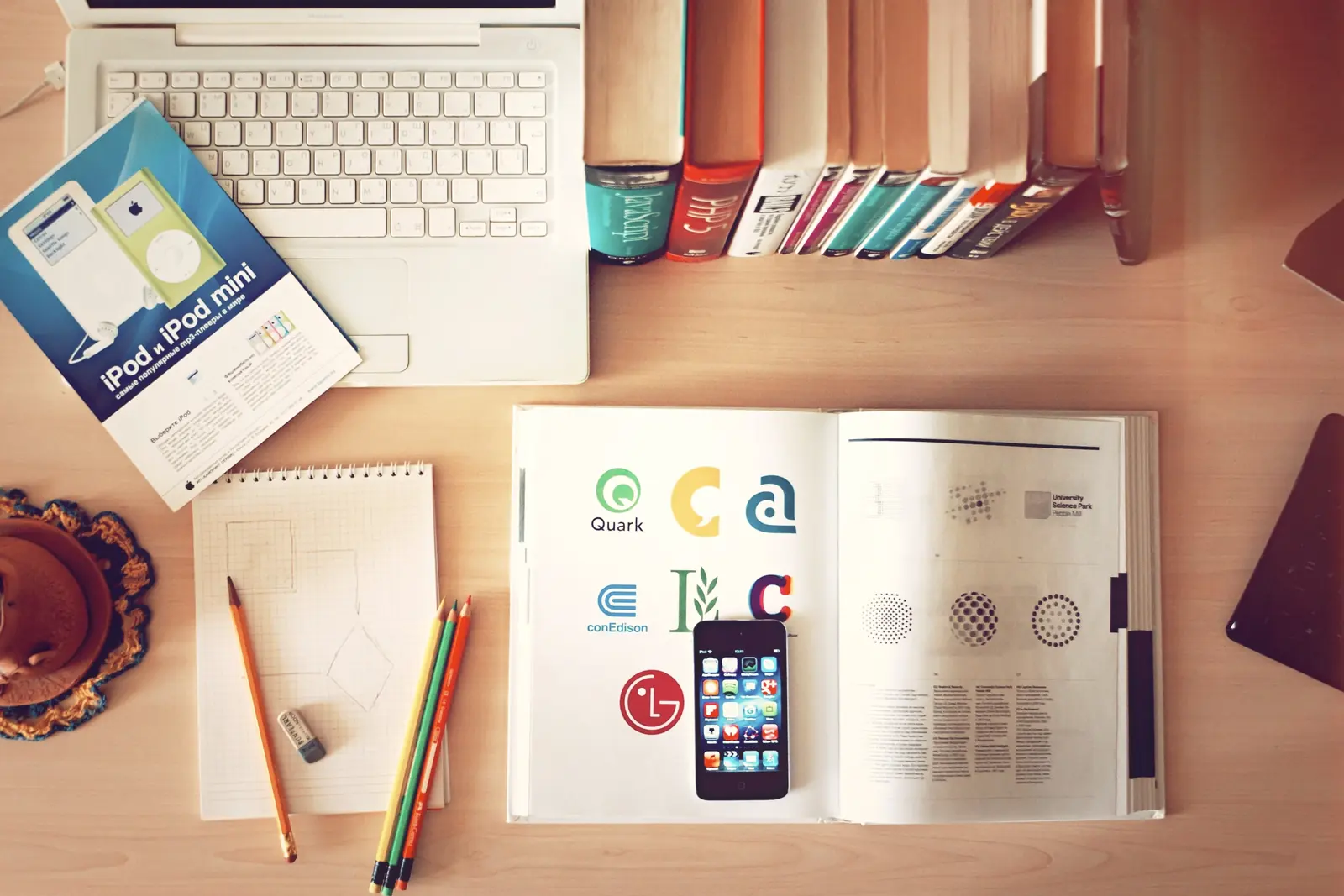 Books, a laptop, and writing tools arranged on a desk.