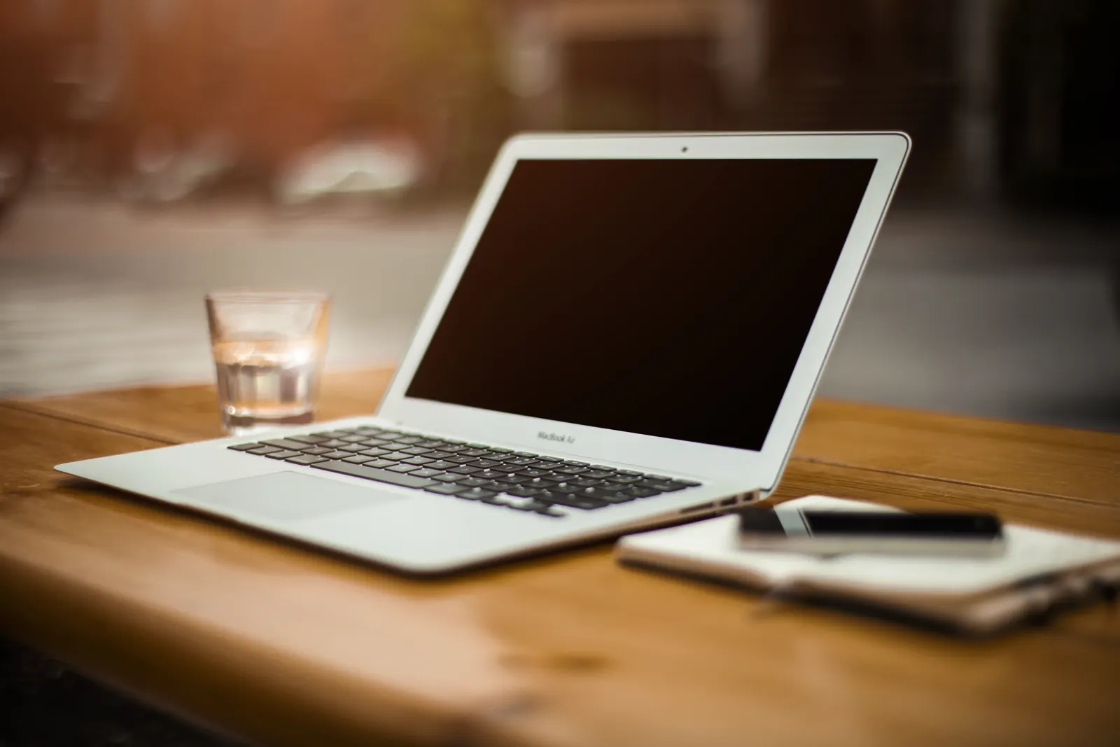 A laptop and open notebook arranged on a desk.
