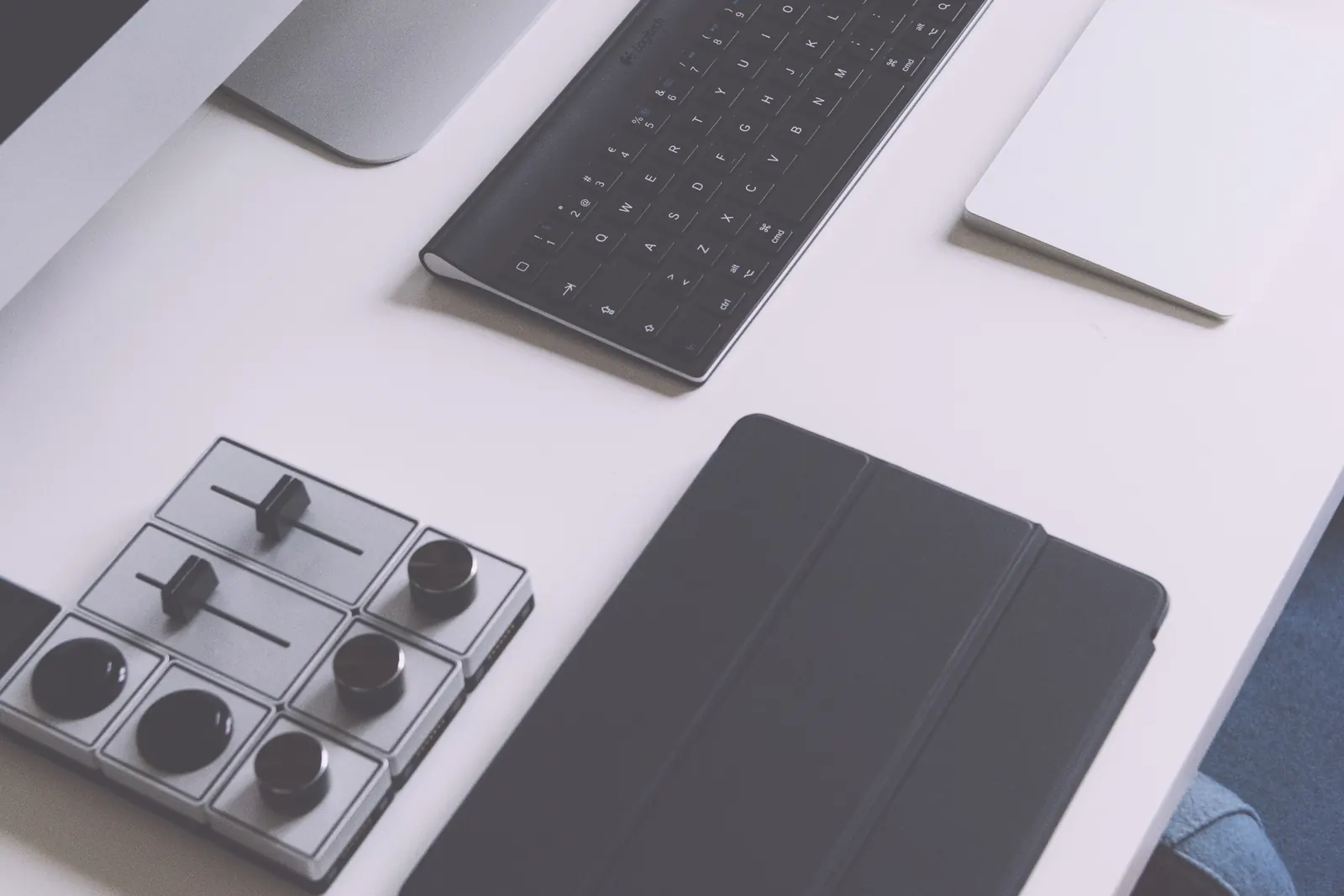 Several computers and accessories arranged across a desk.