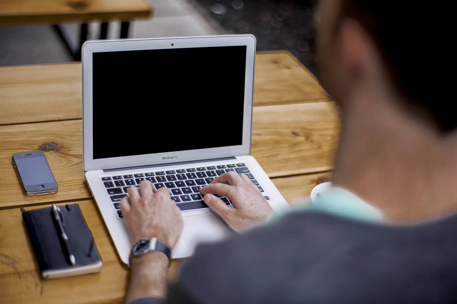 A person typing on a laptop at a desk.