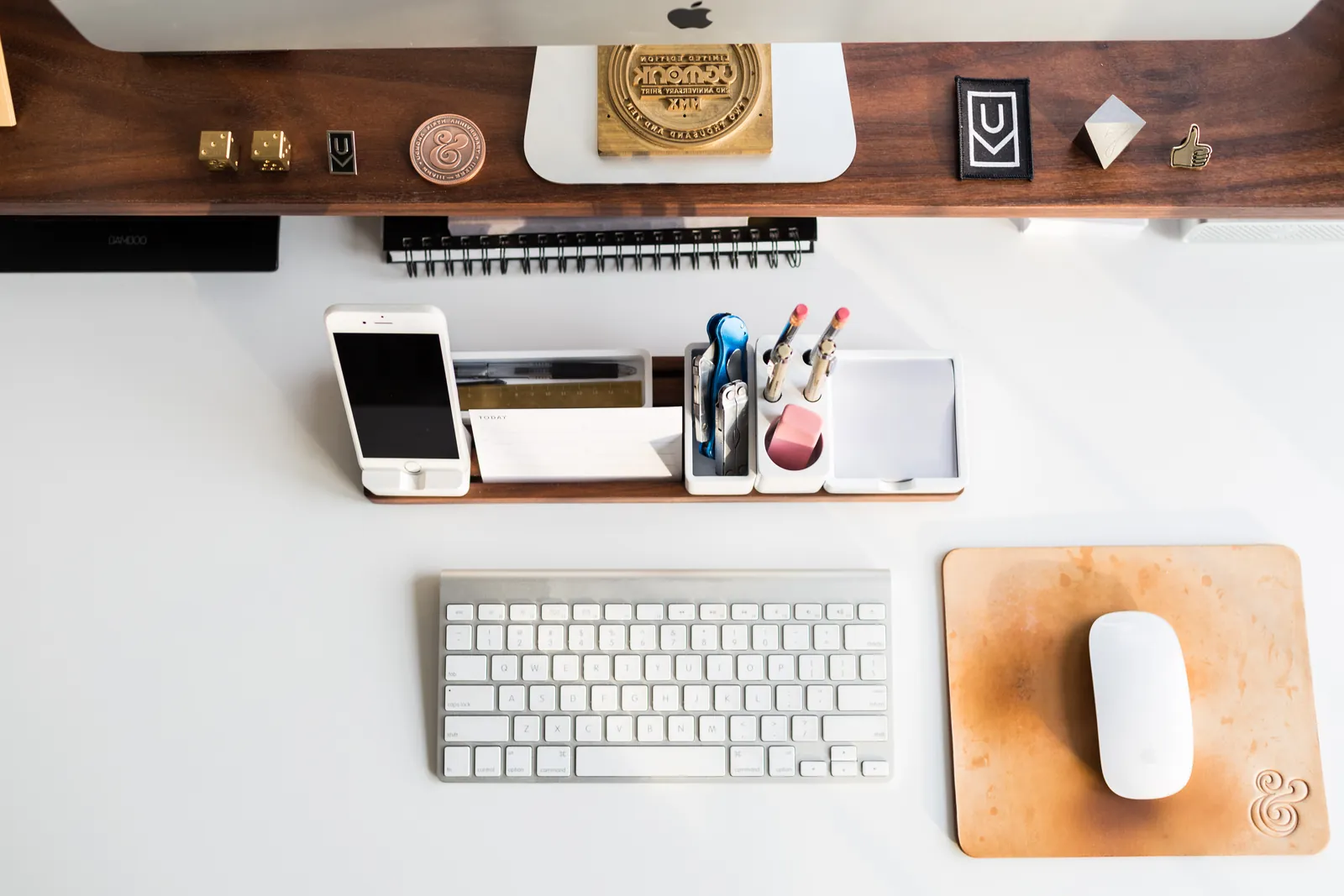 An overhead desk workspace with a laptop, notebook, and coffee cup.