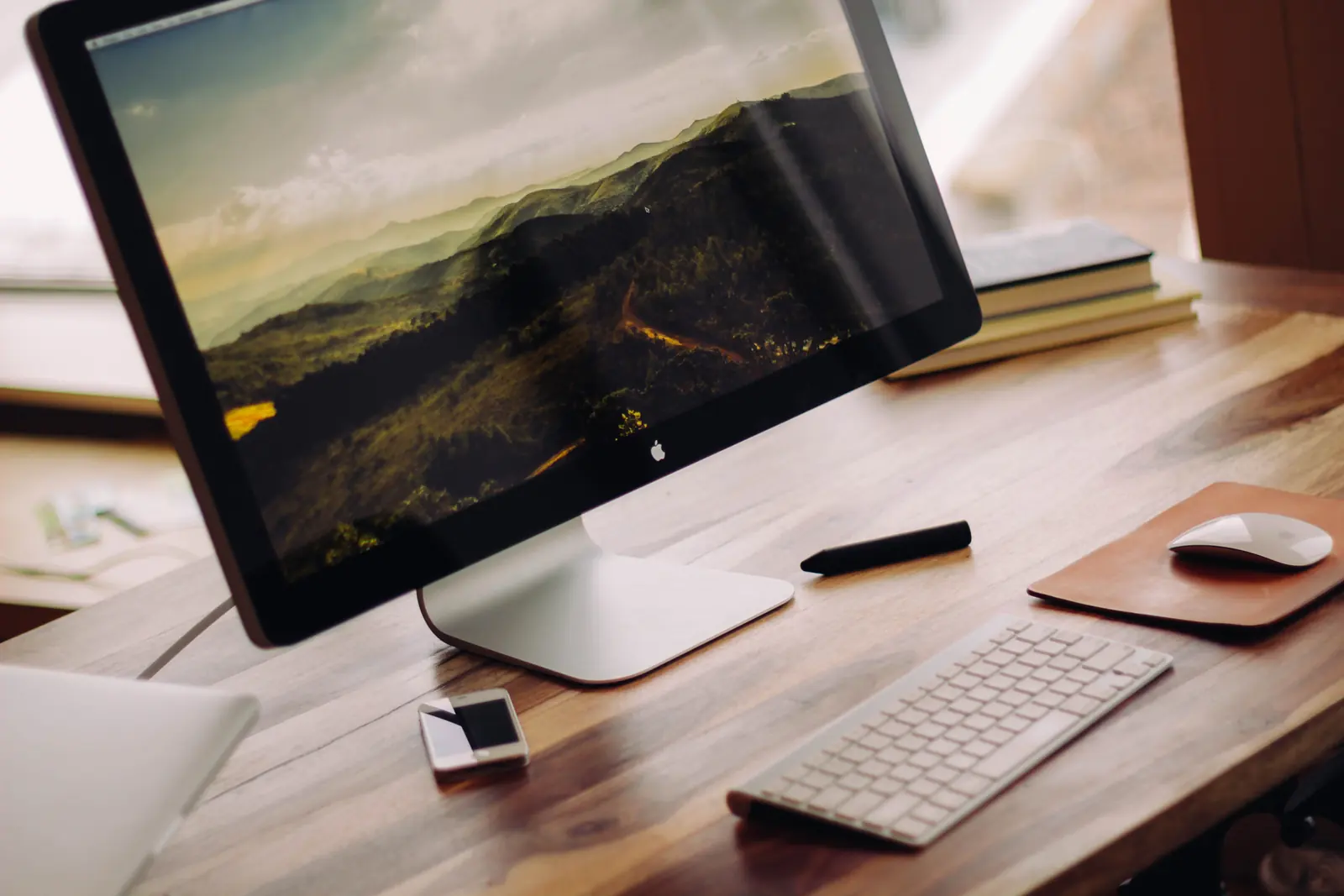 A desktop computer and keyboard on a wooden workspace.