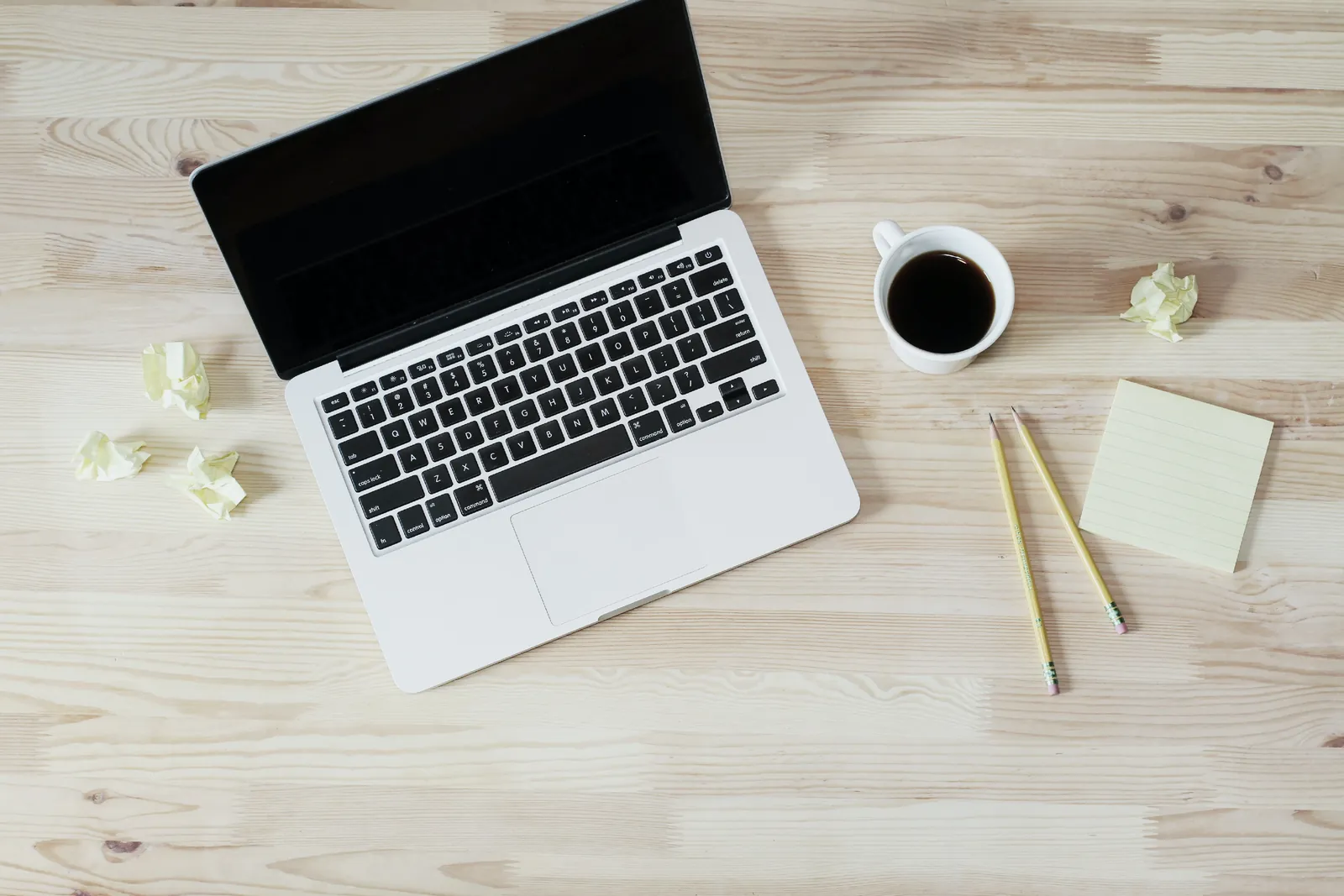 A laptop and coffee arranged on a desk.